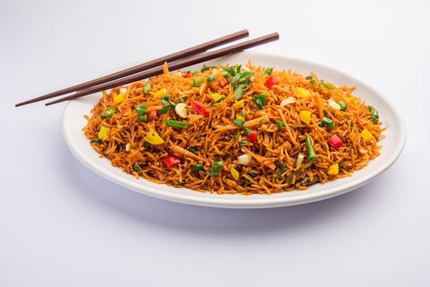 Schezwan fried rice masala of szechuan rijst is een populair indo-chinees gerecht geserveerd in een bord of kom met eetstokjes. selectieve focus