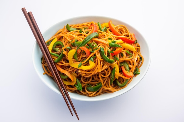 Schezwan noodles of szechwan groente hakka noodles of chow mein is een populaire indo-chinese recepten, geserveerd in een kom of bord met houten eetstokjes
