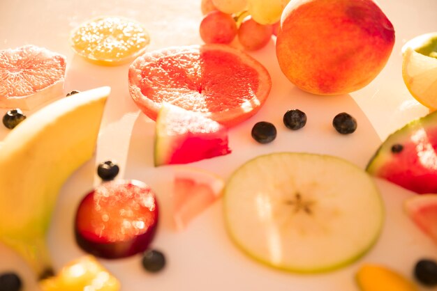 Schijfjes appel; citrusvrucht; Pruim; druivenmost en blauwe bessen in zonlicht