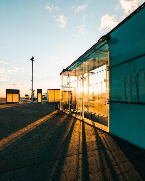 Schilderachtig uitzicht op een gebouw met glazen wanden waar fel zonlicht doorheen gaat tijdens zonsondergang