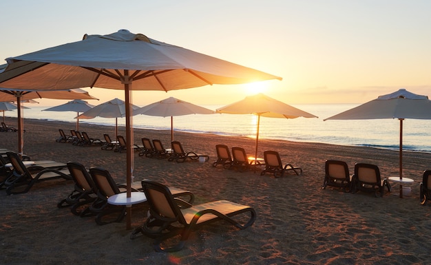 Schilderachtig uitzicht op zandstrand op het strand met open ligbedden en parasols tegen de zee en de bergen. Amara Dolce Vita luxe hotel. Toevlucht. Tekirova-Kemer. kalkoen