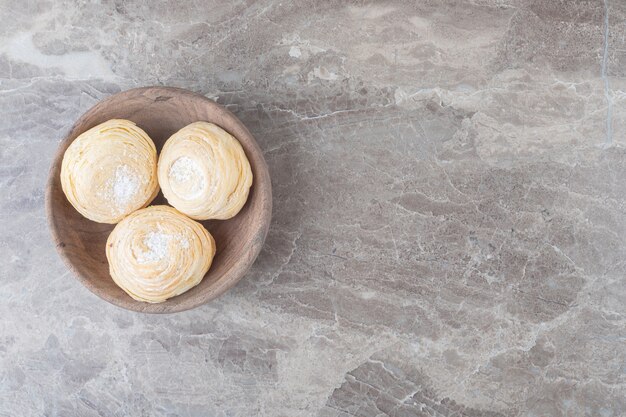 Schilferige koekjes in een kleine kom op marmeren oppervlak