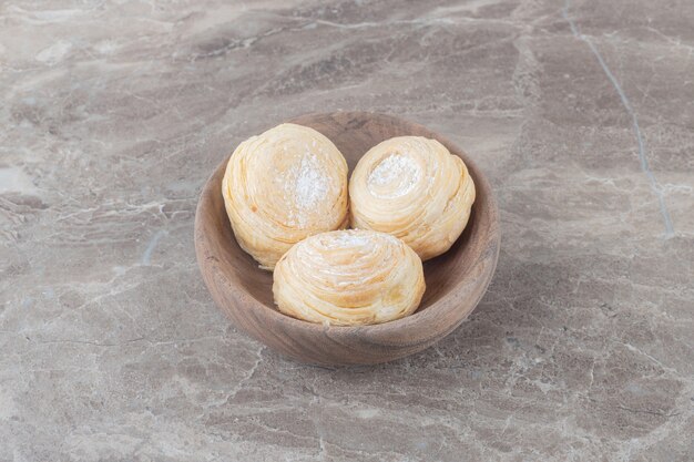 Schilferige koekjes in een kleine kom op marmeren oppervlak