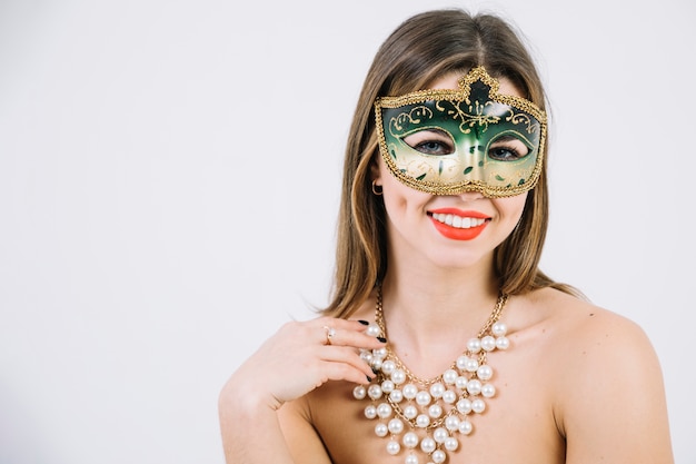 Schitterende glimlachende vrouw in het masker en de halsband van maskeradecarnaval op witte achtergrond