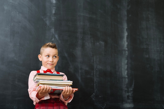 Schooljongen staan ​​met boeken