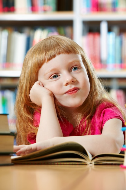 Gratis foto schoolmeisje dagdromen in de bibliotheek