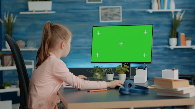 Schoolmeisje kijken naar computer met horizontaal groen scherm