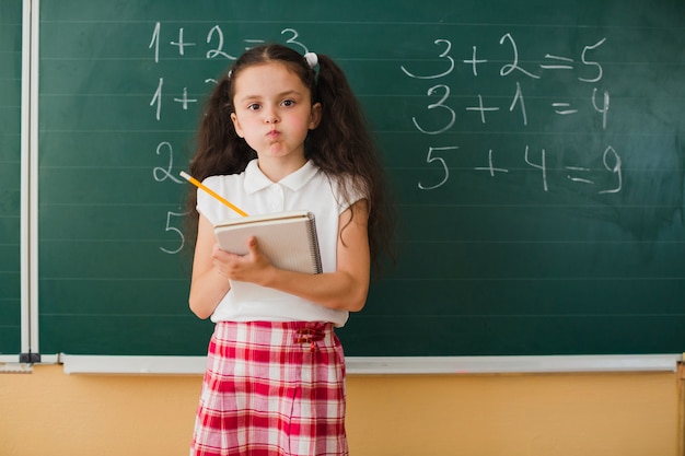 Schoolmeisje met notitieblok grimacing