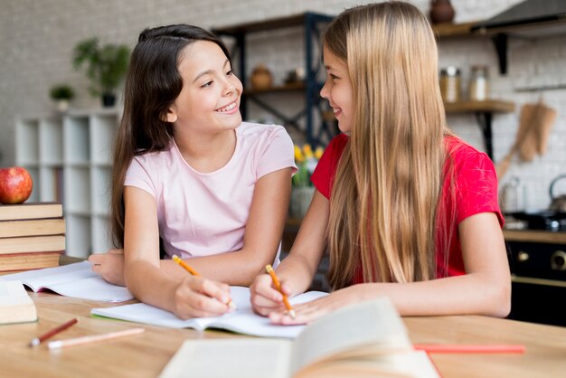 Schoolmeisjes huiswerk maken en naar elkaar kijken