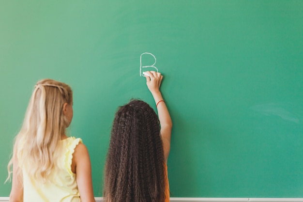 Schoolmeisjes staan ​​voor het bord