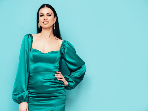 Schoonheid portret van jonge brunette vrouw met avond make-up en perfecte schone huid Sexy model met lang haar poseren in studio geïsoleerd In blauwe jurk