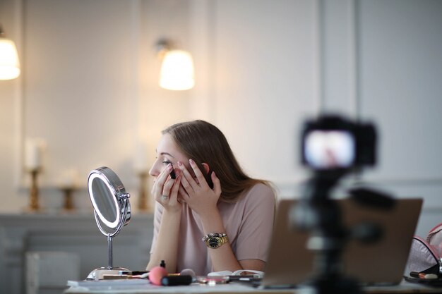 Schoonheid vlogger. Jonge vrouw die een make-uptutorial opneemt