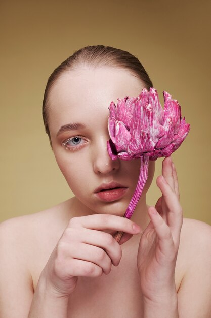 Schoonheidsportret van jonge vrouw met plant