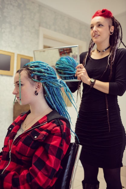 Gratis foto schoonheidsspecialiste die het haar van klanten stylt