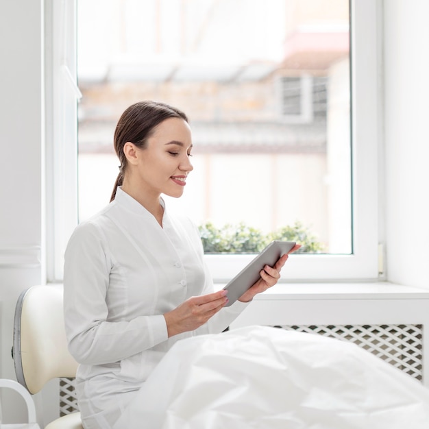 Gratis foto schoonheidsspecialiste vrouw bij kliniek met tablet