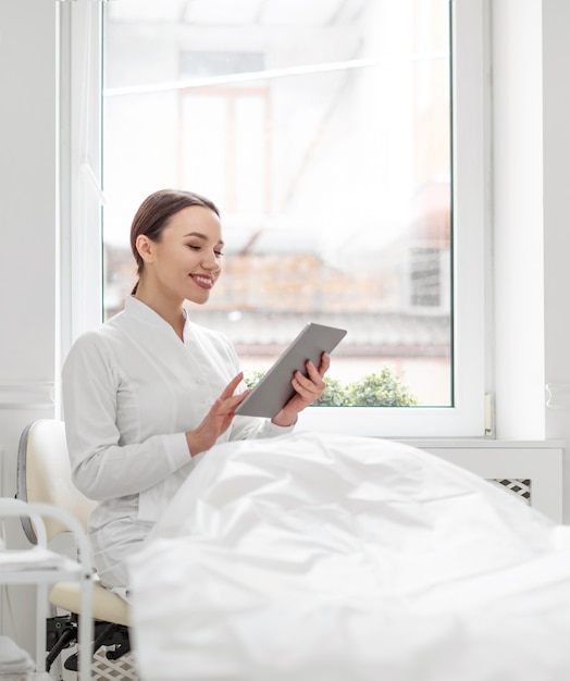 Schoonheidsspecialiste vrouw bij kliniek met tablet