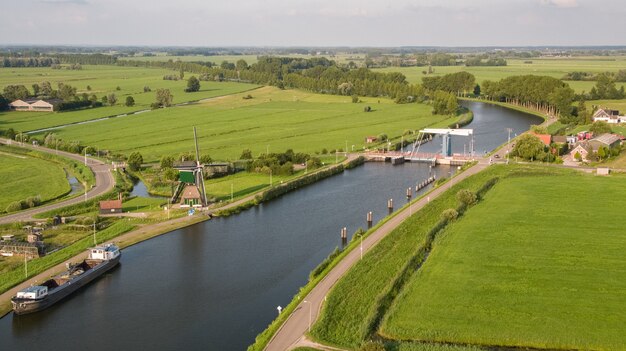 Schot vanuit een hoge hoek van het Merwedekanaal, omringd door grasvelden die zijn vastgelegd in Nehterlands