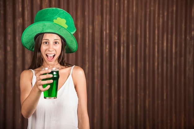 Schreeuwende jonge vrouw die glas van drank toont