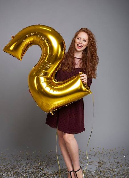 Schreeuwende vrouw met ballon die haar bedrijf tweede verjaardag viert