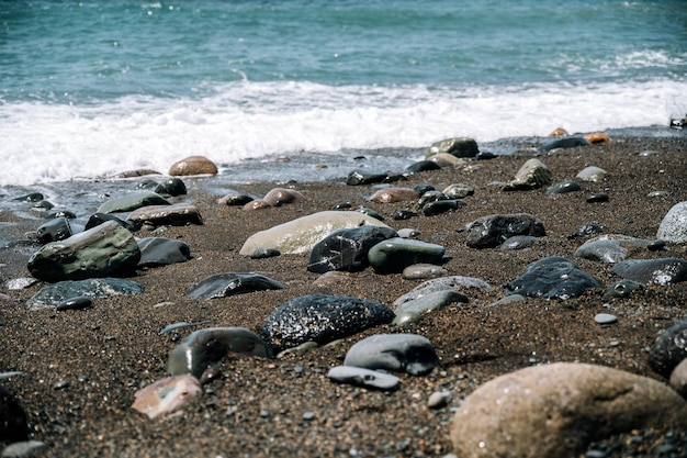 Schuimende zeegolven die de zandige kust wassen