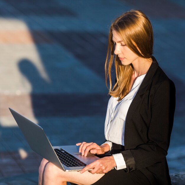 Secretaresse die haar laptop in openlucht met behulp van