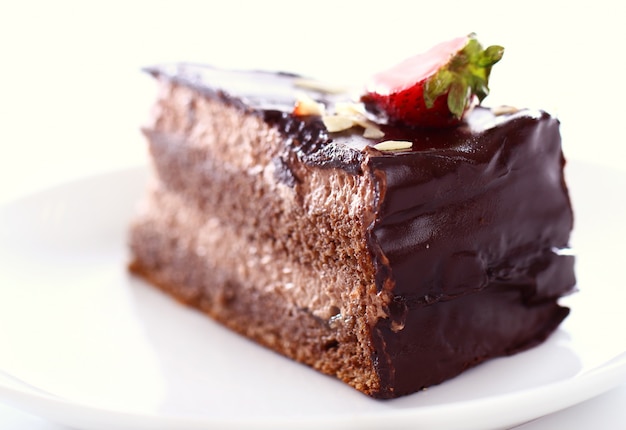 Segment van smakelijke chocoladetaart met aardbei op de top