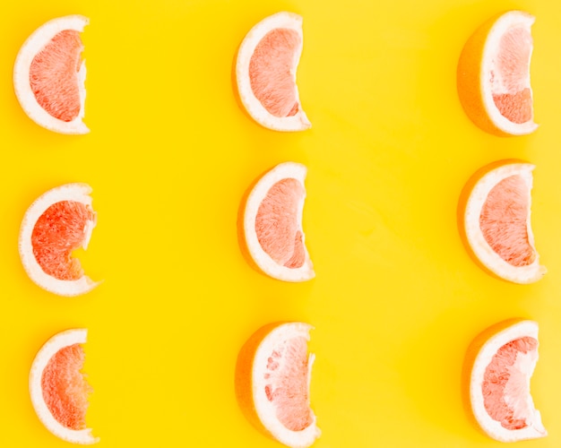 Segmenten van grapefruit op gele achtergrond