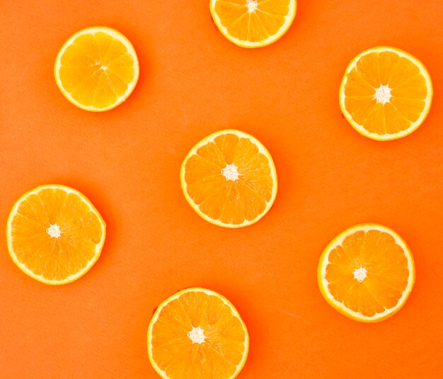 Segmenten van sinaasappelen op gekleurde achtergrond