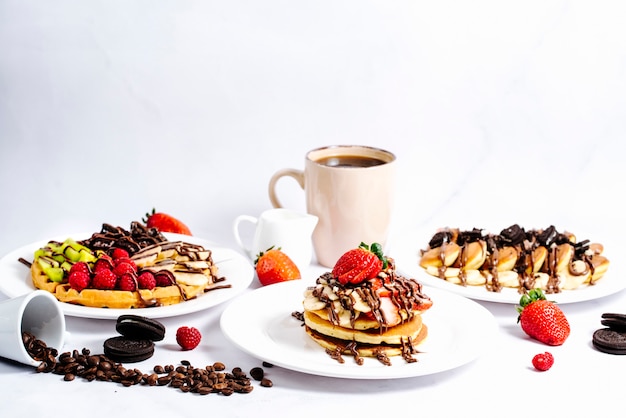 Selectie fruitpannenkoekjes gegarneerd met warme chocolademelk