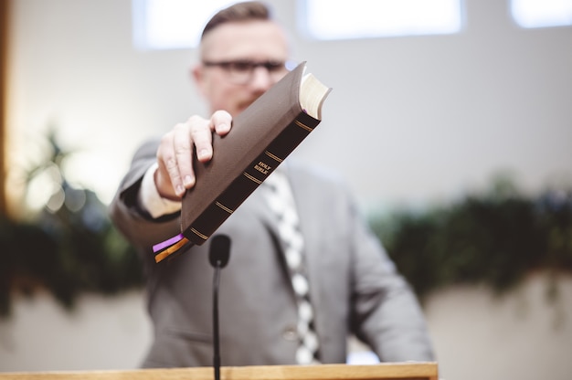 Gratis foto selectieve aandacht die van een mannetje is ontsproten dat en een boek in handen houdt