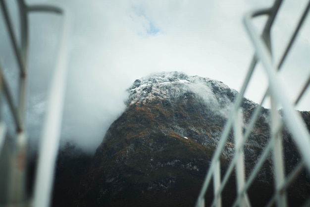 Selectieve focus fotografie van hoge rotsachtige bergen bedekt met sneeuw en mist