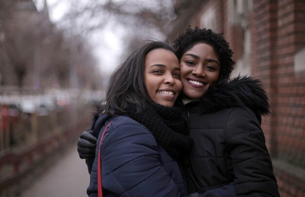 Selectieve focus shot van twee omhelsde vriendinnen in de straat