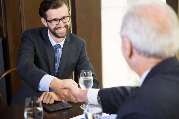 Senior business man die een handdruk van een andere zakenman