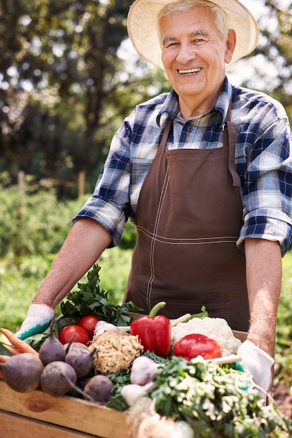 Senior man aan het werk in het veld met bloemen