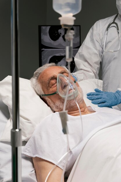 Senior man ademen met een speciale uitrusting in het ziekenhuis
