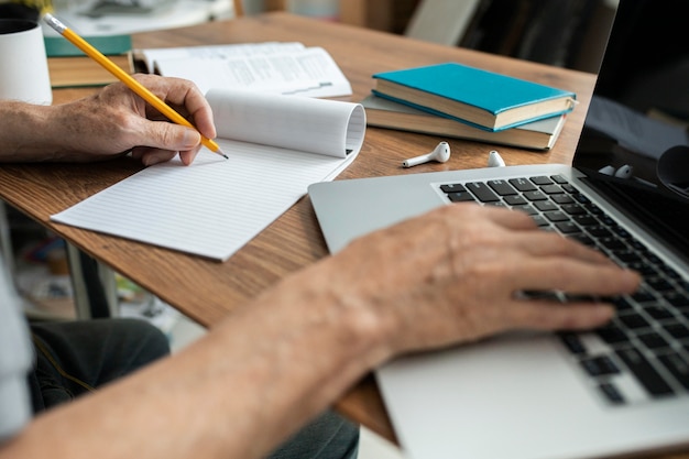 Senior man doet online lessen op een laptop