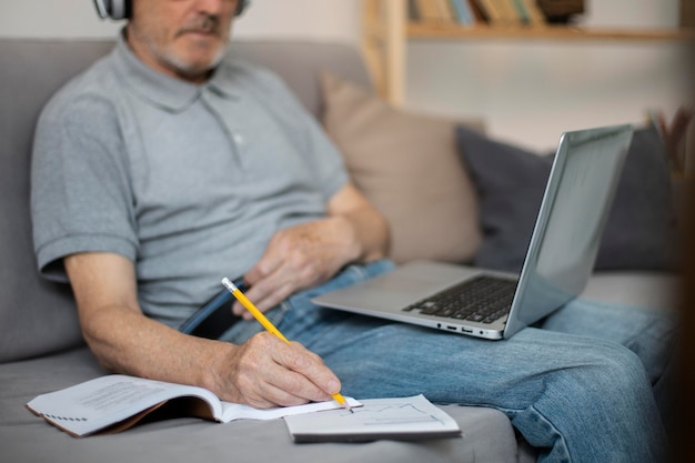 Senior man doet online lessen op een laptop