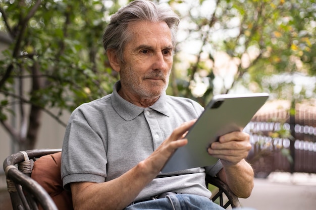 Senior man doet online lessen op een tablet