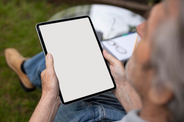 Gratis foto senior man doet online lessen op een tablet
