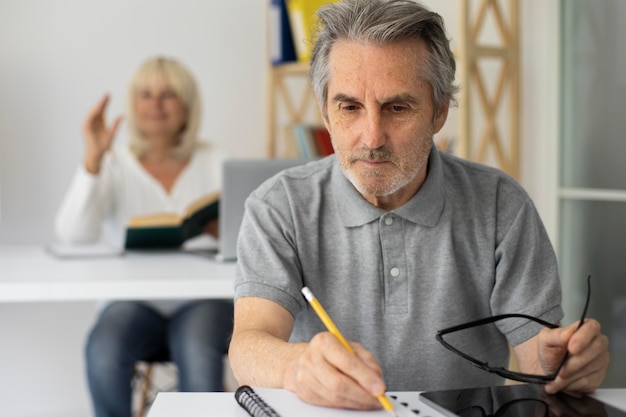 Senior man en vrouw die opletten in de klas