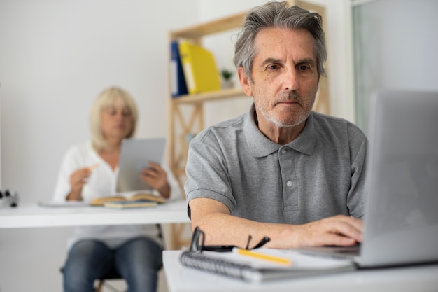 Senior man en vrouw die opletten in de klas