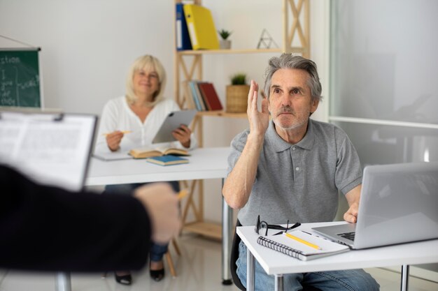 Senior man en vrouw die opletten in de klas
