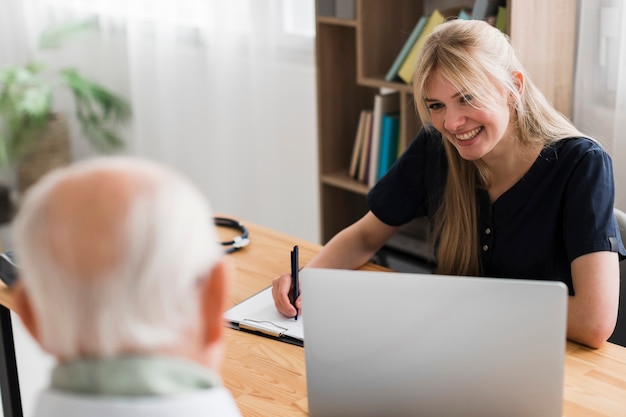 Senior man in een verpleeghuis wordt gecontroleerd door verpleegkundige