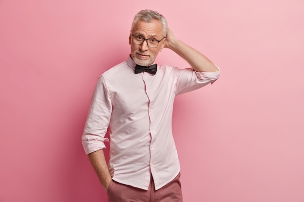 Senior man in roze shirt en zwarte bowtie