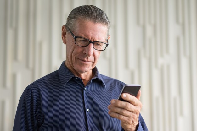 Senior Man Lezing Info op Smartphone