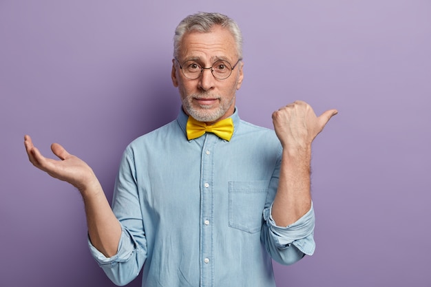 Gratis foto senior man met blauw shirt en gele bowtie