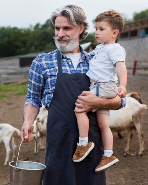Senior man met kleinzoon op de boerderij