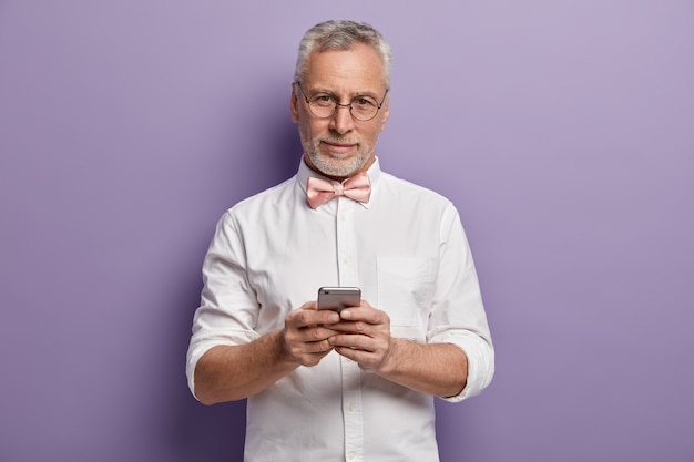 Senior man met wit overhemd en roze bowtie