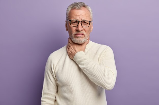 Senior man met witte trui en trendy bril