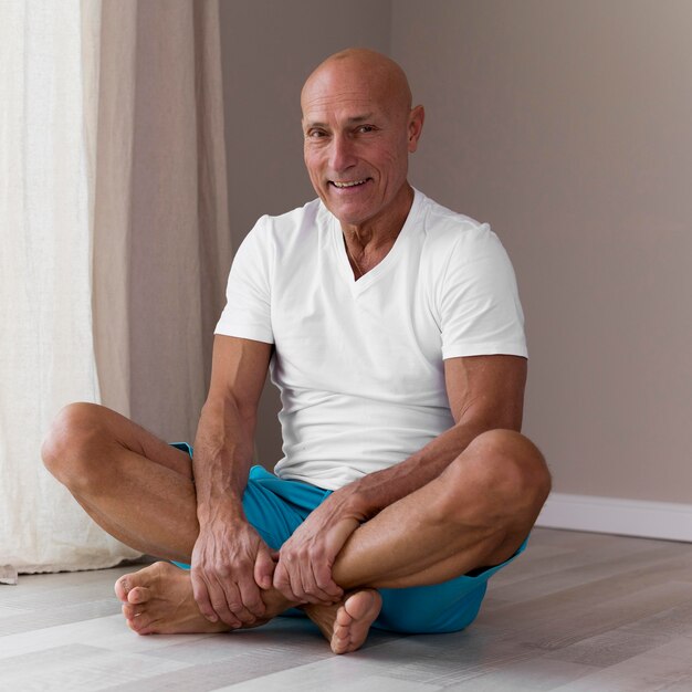 Senior man zit in yoga lotuspositie